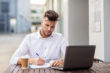 Image showing man with laptop and coffee at city cafe