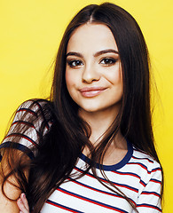 Image showing young pretty teenage woman emotional posing on yellow background, fashion lifestyle people concept