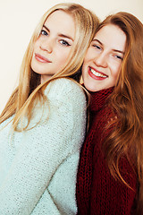 Image showing Two young girlfriends in winter sweaters indoors having fun. Lif