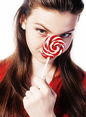 Image showing young pretty brunette girl with red candy posing on white backgr