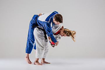 Image showing The two judokas fighters posing on gray