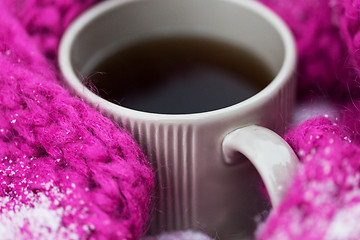 Image showing close up of tea or coffee and winter scarf in snow