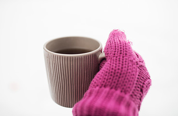 Image showing close up of hand in winter mitten holding tea mug