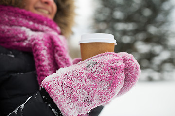 Image showing close up of hand with coffee outdoors in winter