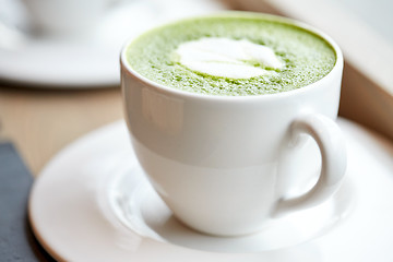 Image showing white cup of matcha green tea latte on table