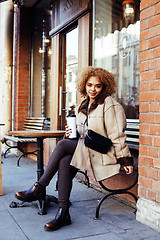 Image showing young pretty african american women drinking coffee outside in c