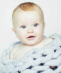 Image showing little cute red head baby in scarf all over him close up isolate