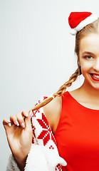 Image showing young pretty happy smiling blond woman on christmas in santas red hat and holiday decorated plaid, lifestyle people concept