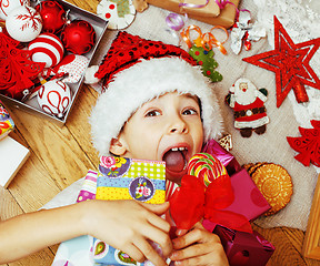 Image showing little cute boy with Christmas gifts at home. close up emotional