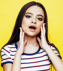 Image showing young pretty teenage woman emotional posing on yellow background, fashion lifestyle people concept