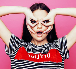 Image showing young pretty teenage woman emotional posing on pink background, fashion lifestyle people concept