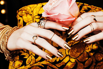 Image showing woman hands with golden manicure lot of jewelry on fancy dress c