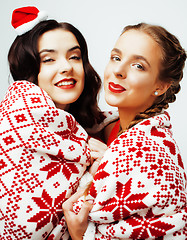 Image showing young pretty happy smiling blond and brunette woman girlfriends on christmas in santas red hat and holiday decorated plaid, lifestyle people concept