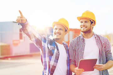 Image showing smiling builders in hardhats with tablet pc