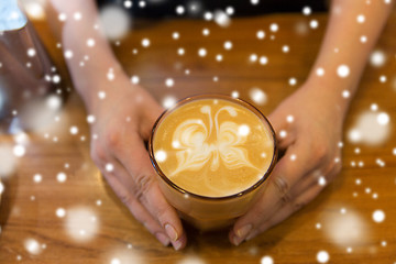 Image showing close up of hands with latte art in coffee cup