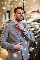 Image showing young man trying suit on in clothing store