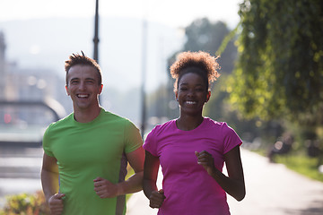 Image showing young multiethnic couple jogging in the city