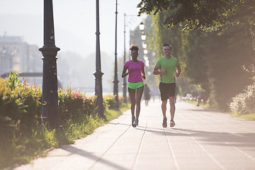 Image showing young multiethnic couple jogging in the city