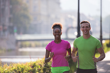 Image showing young multiethnic couple jogging in the city