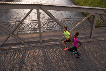 Image showing young multiethnic couple jogging in the city