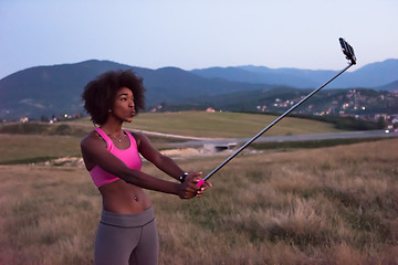 Image showing black woman photographing herself in nature