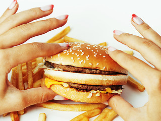 Image showing woman hands with manicure holding hamburger and french fries iso