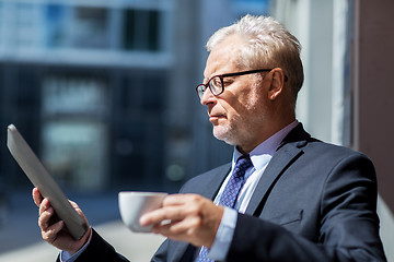 Image showing senior businessman with tablet pc drinking coffee