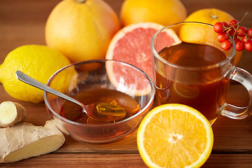 Image showing tea with honey, lemon and ginger on wood