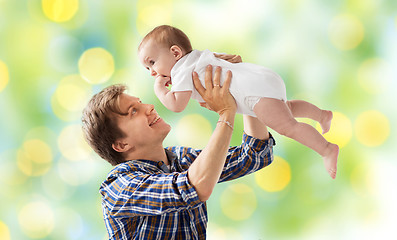 Image showing happy young father playing with baby over lights