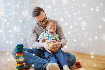 Image showing father and son playing with ball clay at home