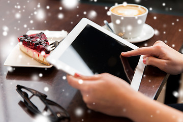 Image showing close up of hands with tablet pc, coffee and cake