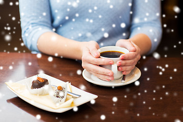 Image showing close up of woman holding coffee cup and dessert