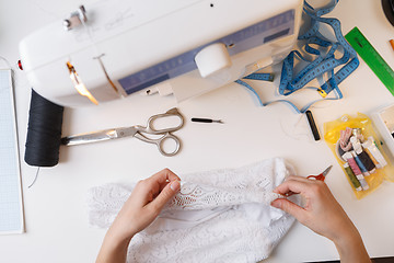 Image showing Dressmaker working with white cloth