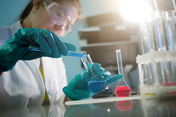 Image showing Young laboratory assistant with flasks