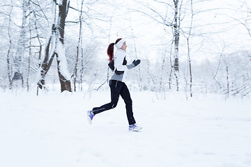 Image showing Woman jogging in winter woods