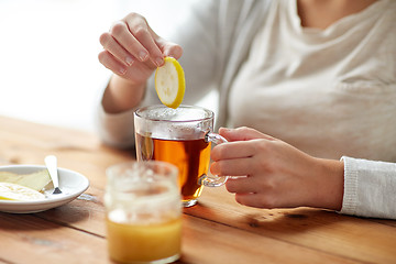 Image showing close up of ill woman drinking tea with lemon