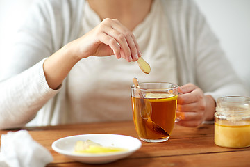 Image showing close up of ill woman drinking tea with ginger