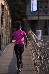 Image showing african american woman running across the bridge