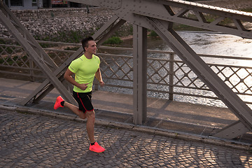 Image showing a young man jogging in the city