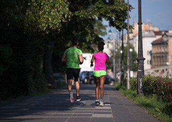 Image showing young smiling multiethnic couple jogging in the city