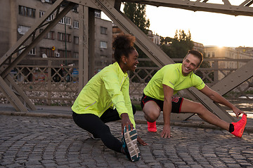 Image showing jogging couple warming up and stretching in the city