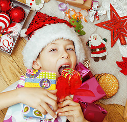 Image showing little cute kid in santas red hat with handmade gifts, toys vintage wooden, warm winter