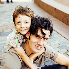 Image showing little son with father in city hagging and smiling, casual look outside playing, happy real family, lifestyle people concept