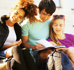 Image showing cute group of teenages at the building of university with books 