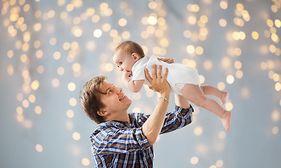 Image showing happy young father playing with baby over lights