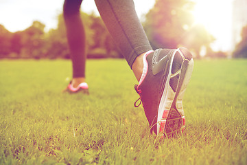 Image showing close up of exercising woman legs on grass in park