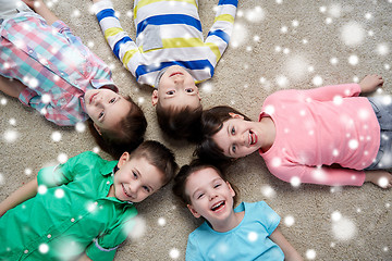 Image showing happy smiling children lying on floor over snow