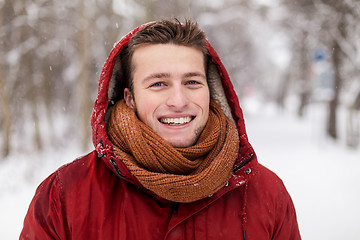 Image showing happy man in winter jacket with hood outdoors