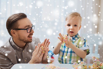 Image showing father and son playing with ball clay at home