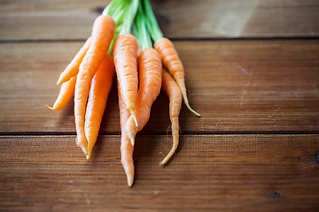 Image showing close up of carrot bunch on wooden table